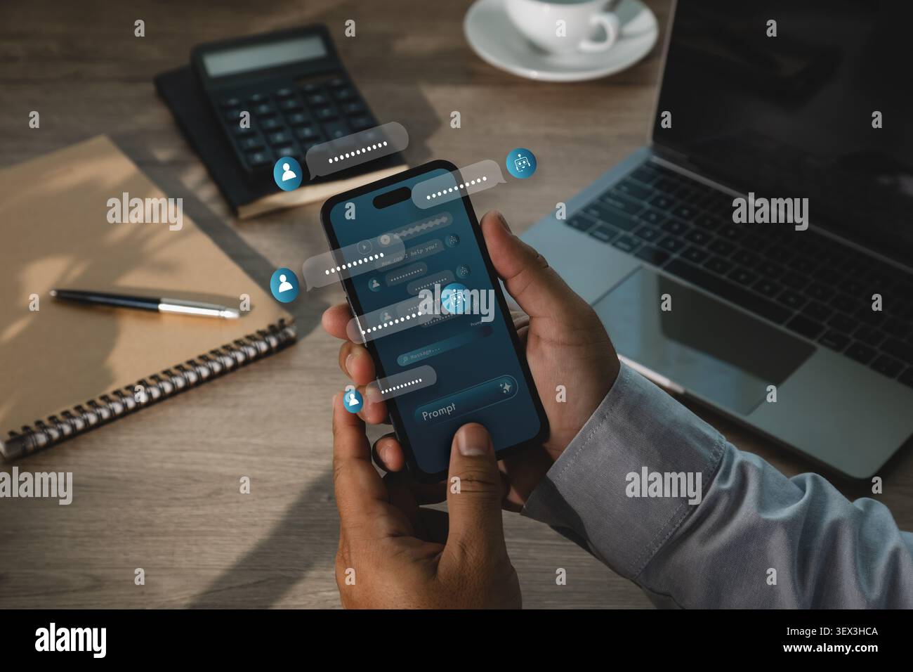 Hand uses smartphone with AI chatbot interface, floating message bubbles, prompt icons and laptop workspace, showing digital assistant communication a Stock Photo