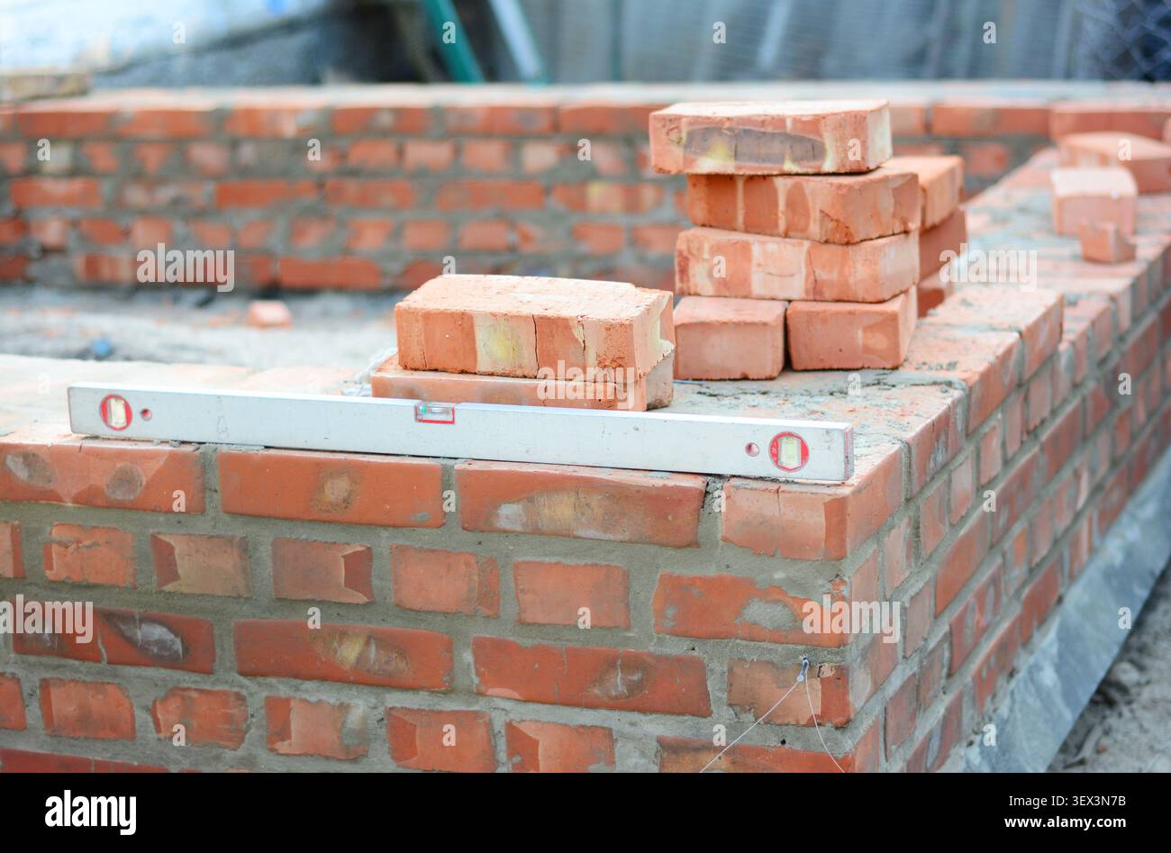 Construction Worker Checking Brick Wall Level During Masonry Stock Photo