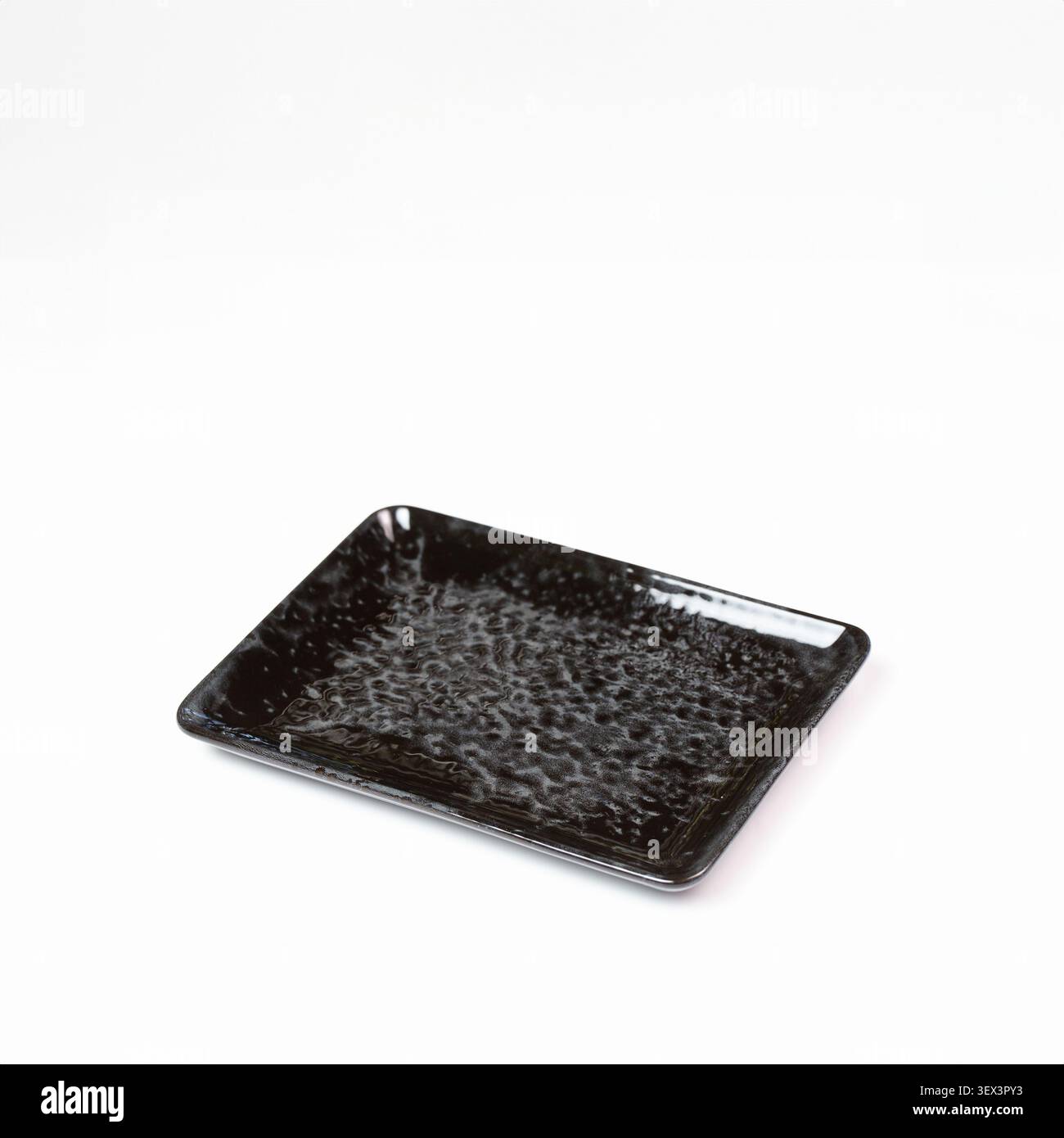 Empty black textured ceramic tray on white background isolated studio close shot Stock Photo
