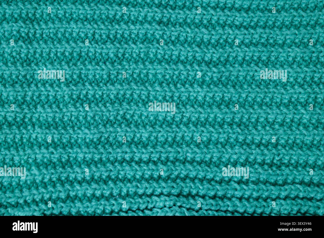 Teal wool knitting pattern showing textured fabric background Stock Photo