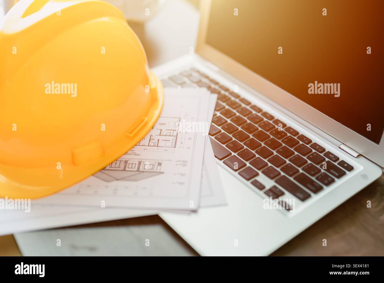 Construction Engineer Safety Helmets on Laptop Computer Architect Office Desk, Home Construction Engineers Project Design. Stock Photo