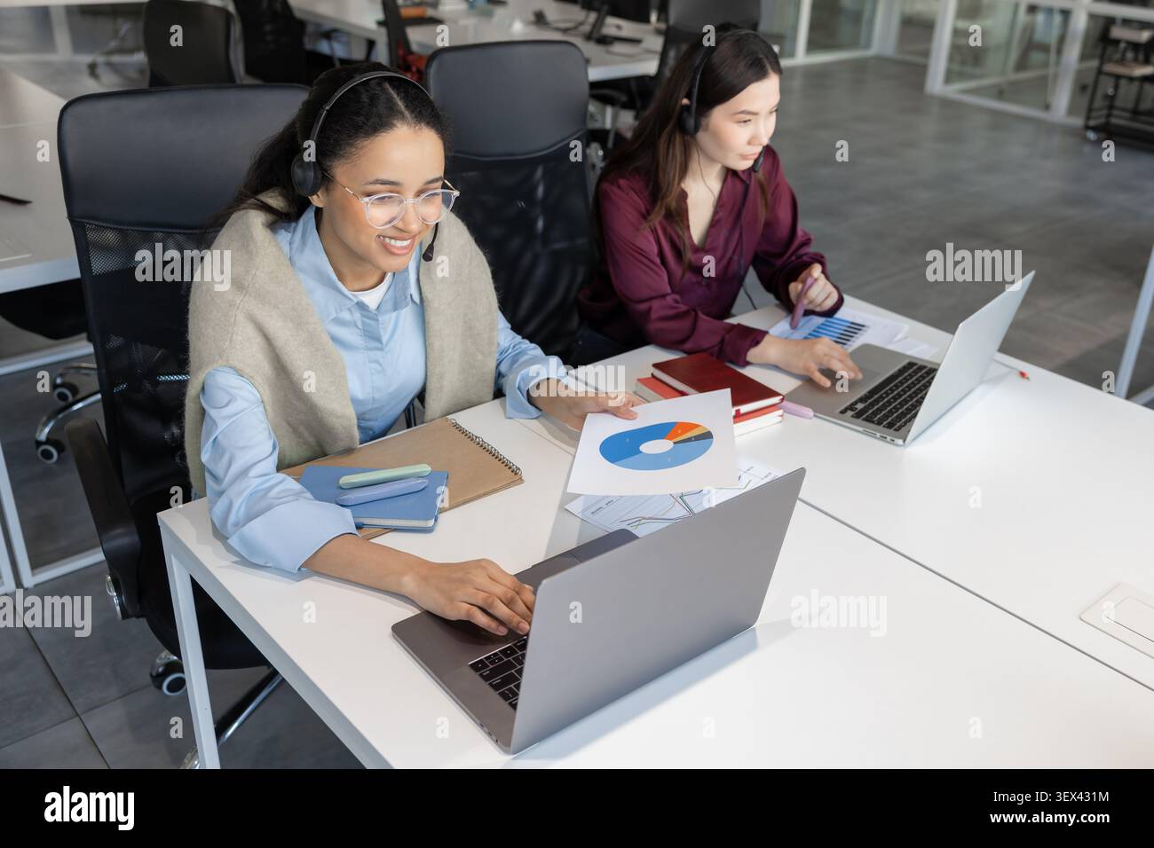Young women call center agents using laptops Stock Photo