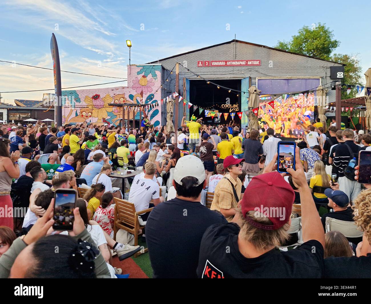 Large crowd watching FIFA World Cup match on giant outdoor screen. Football fans gathering at outdoor venue to watch Brazil Japan match. - Smartphone Captured Stock Image