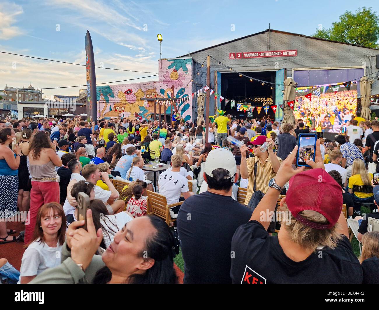 Large crowd watching FIFA World Cup match on giant outdoor screen. Football fans gathering at outdoor venue to watch Brazil Japan match. - Smartphone Captured Stock Image