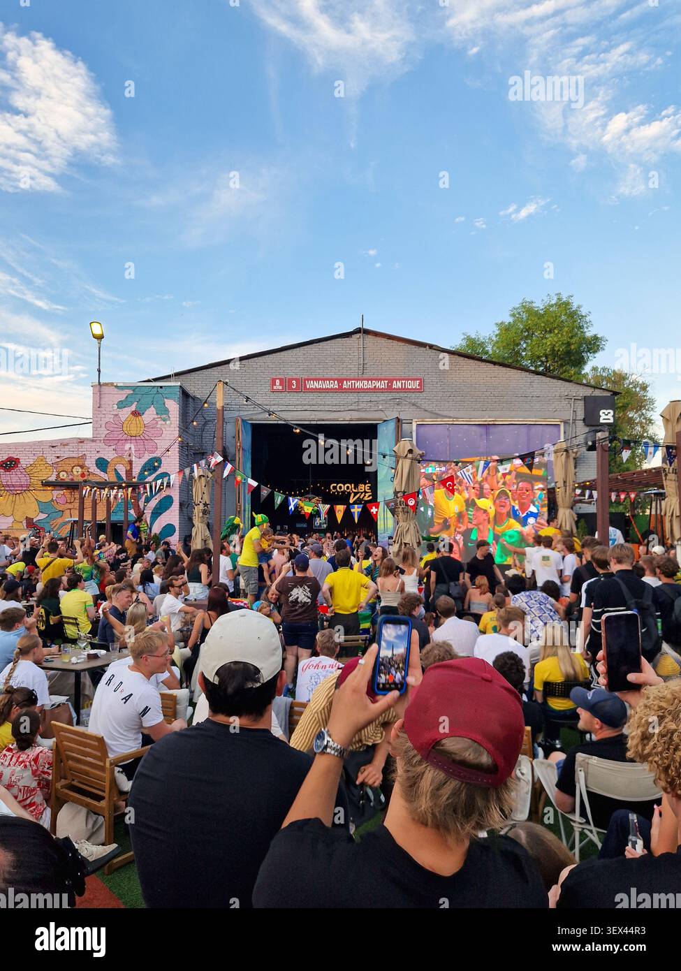 Large crowd watching FIFA World Cup match on giant outdoor screen. Football fans gathering at outdoor venue to watch Brazil Japan match. - Smartphone Captured Stock Image