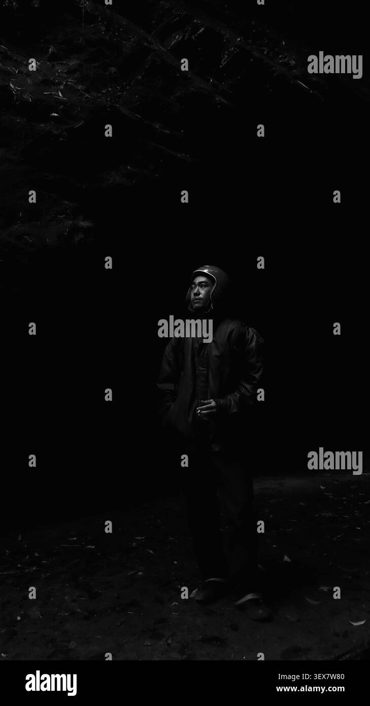 Dramatic Monochrome Portrait of Male Motorcyclist in Helmet on Ha Giang Road Trip Stock Photo