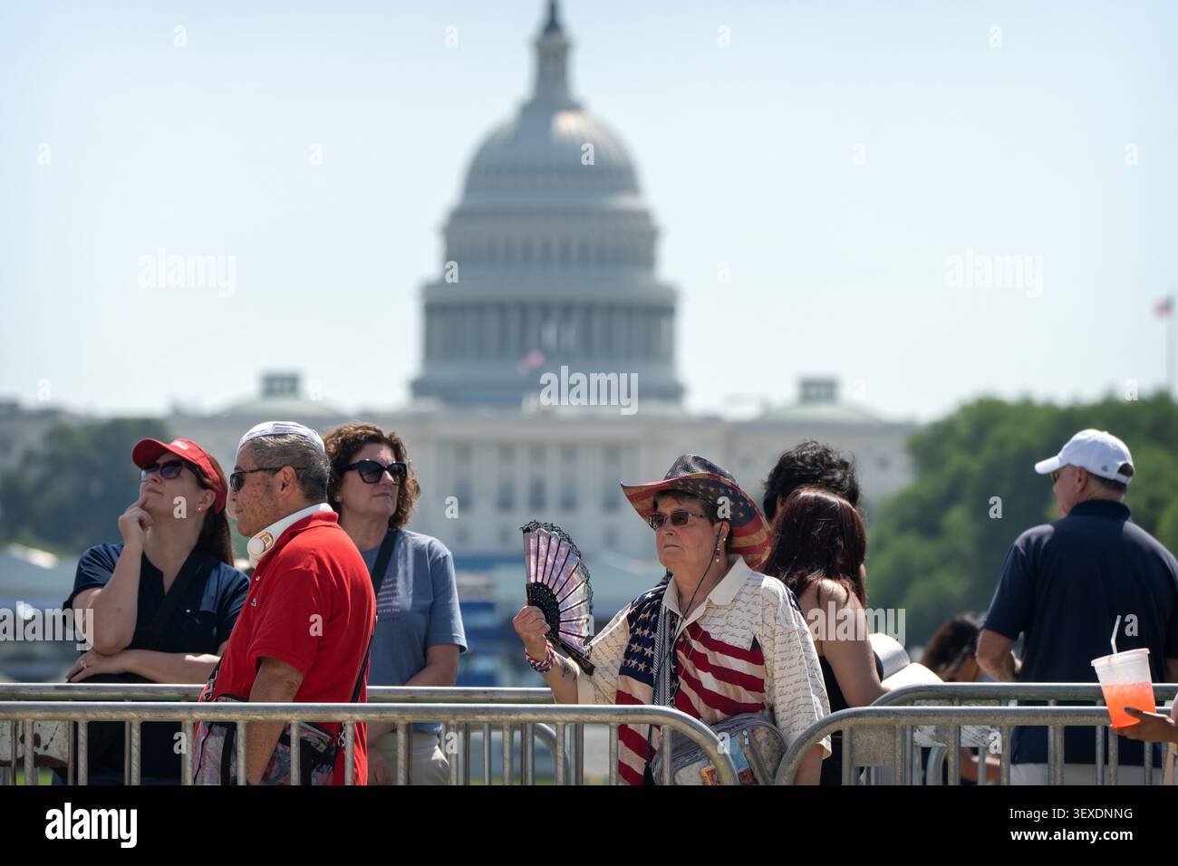 A visitor fans herself to keep cool as she waits in a line at the Great ...