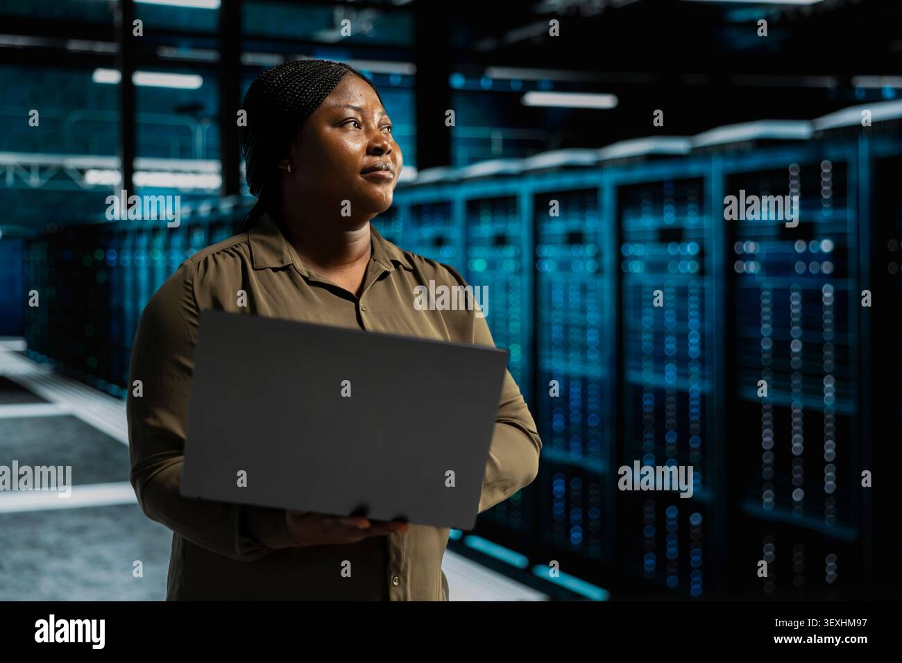 IT expert provides technical support from a data center using a headset while troubleshooting client server issues. Stock Photo
