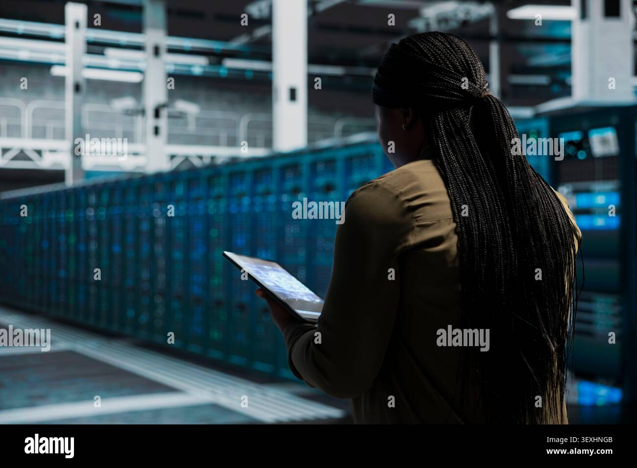 Computer scientist works with a computer workstation in a server room to support artificial intelligence systems. Stock Photo