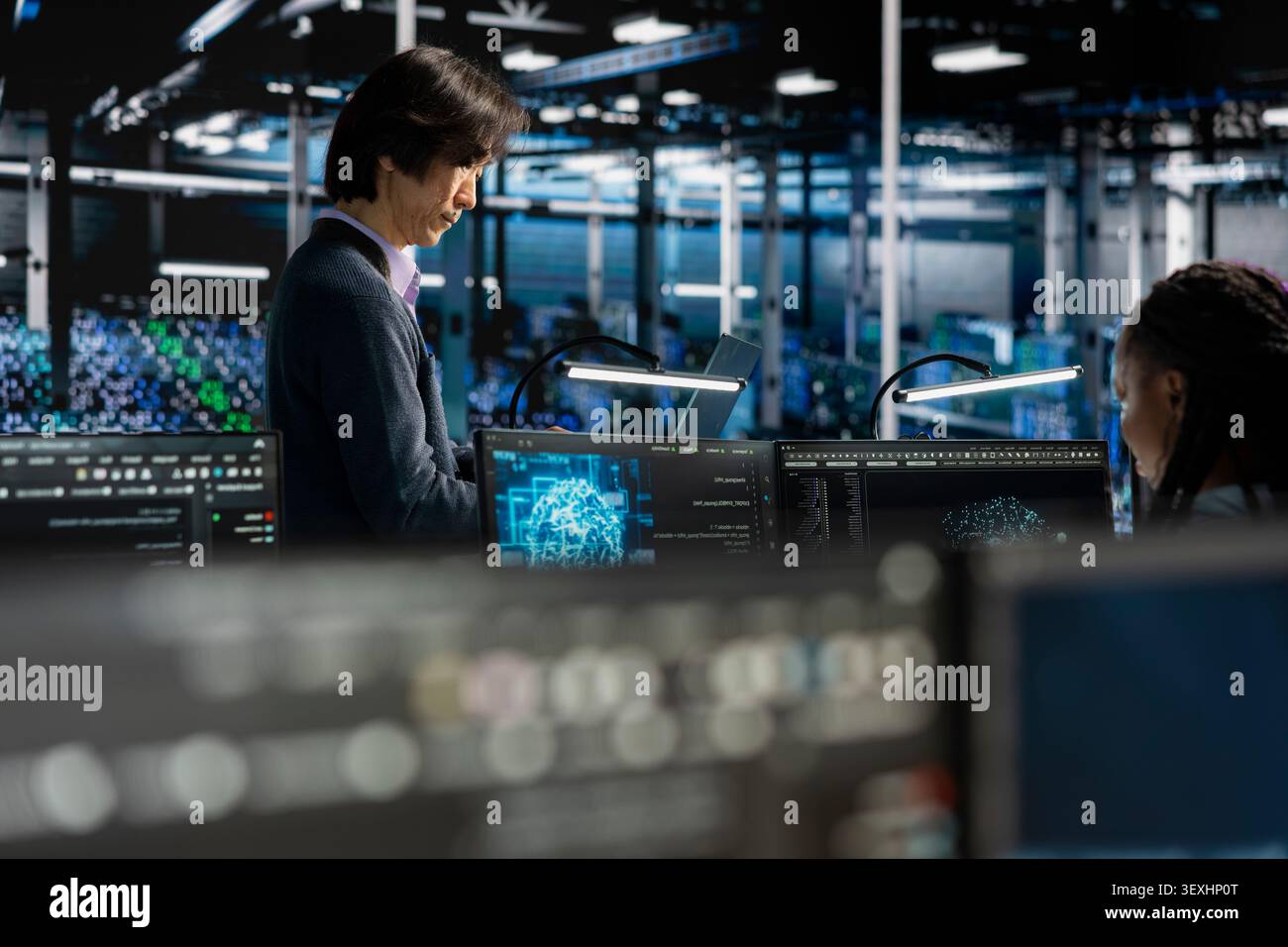 System administrators tune AI model settings on a computer workstation in a server farm to improve accuracy. Stock Photo