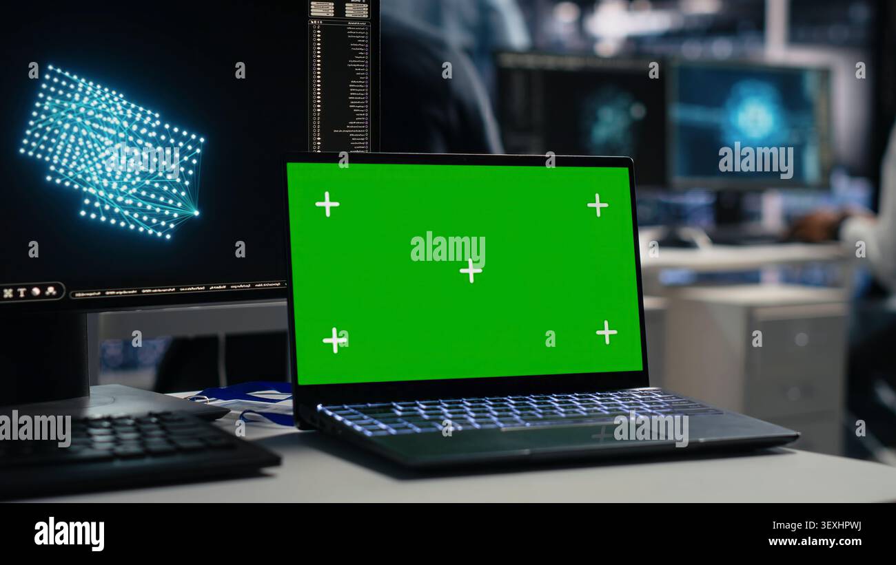 Software developer uses a green screen laptop to manage AI systems, machine learning workflows and server performance. Stock Photo