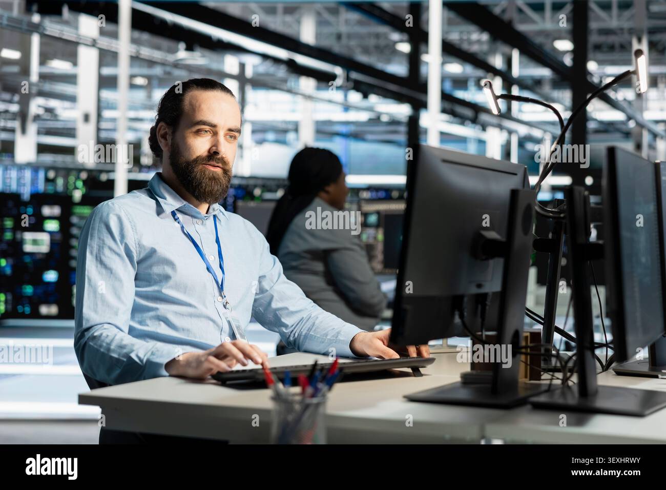 Data center programmer uses a computer to run diagnostics, update servers and check infrastructure performance. Stock Photo