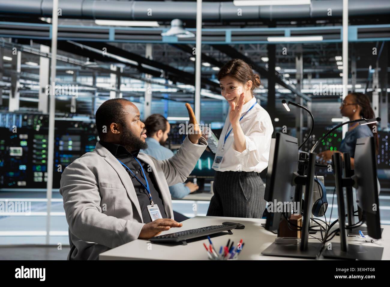 Delighted data center colleagues share a high five after improving system efficiency and completing AI implementation. Stock Photo
