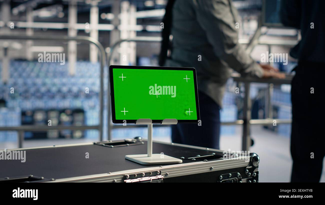 Software developer uses a green screen tablet to manage AI systems, machine learning workflows and server performance. Stock Photo