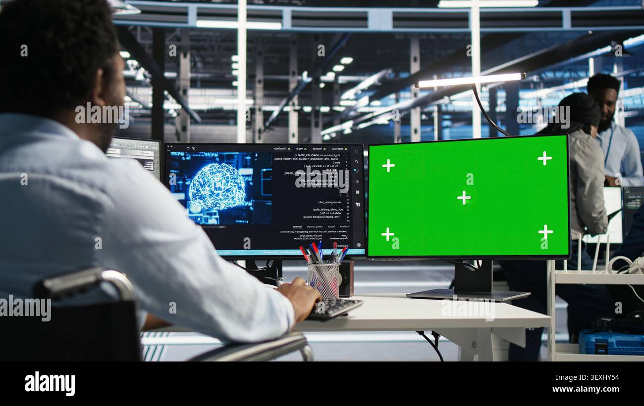 Computing facility technical specialist with paraplegia working with AI deep learning algorithms on chroma key computer to assess datasets while seated seated at chroma key computer using AI tools. Stock Photo