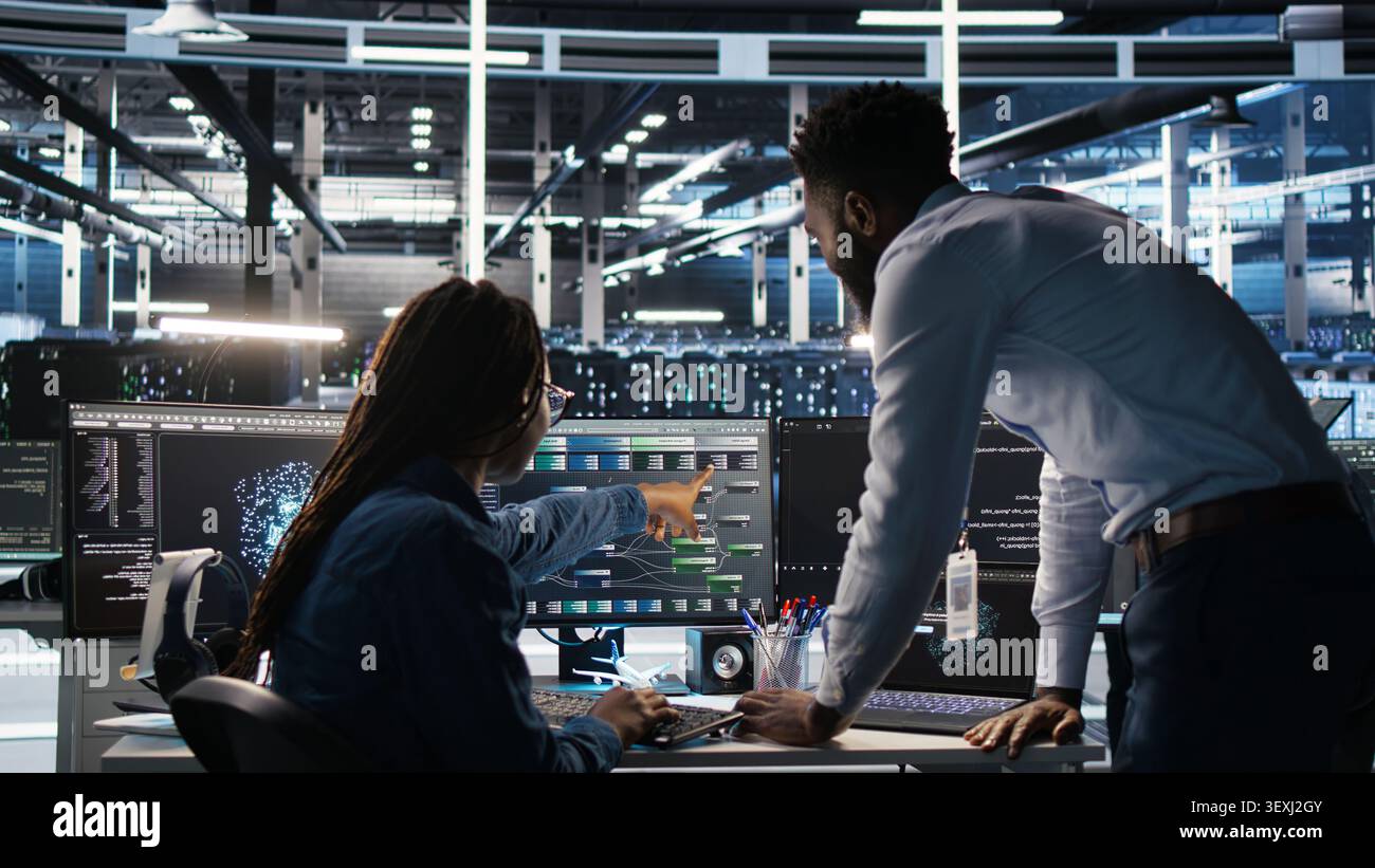 High tech server room team supervisor supervising technical specialist. Stock Photo