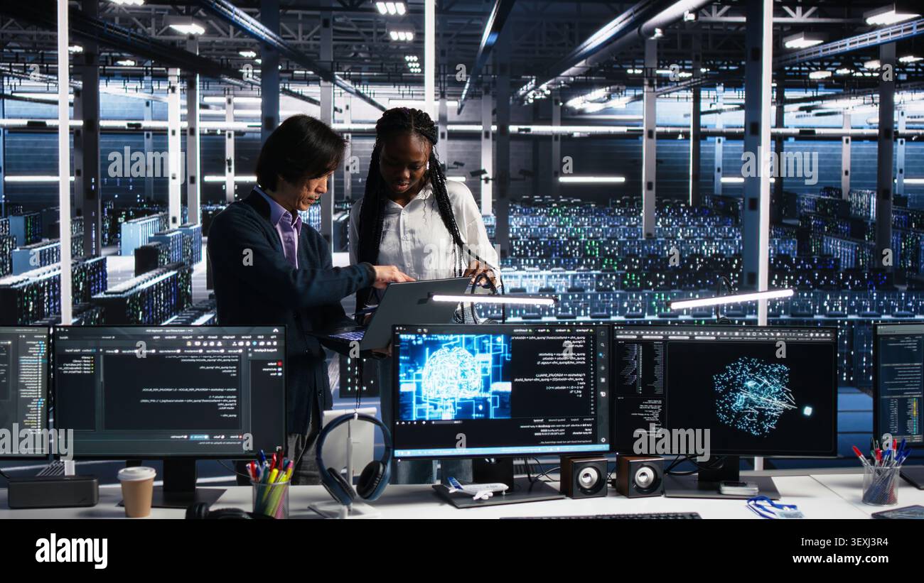Multiethnic data center engineers review paperwork and use deep learning algorithms to analyze datasets and recognize patterns. Stock Photo