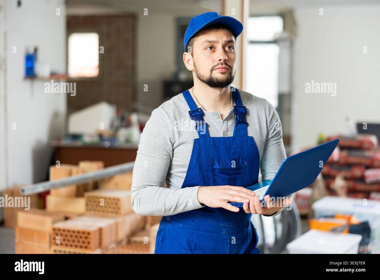 Contractor using laptop while working at construction site indoors Stock Photo