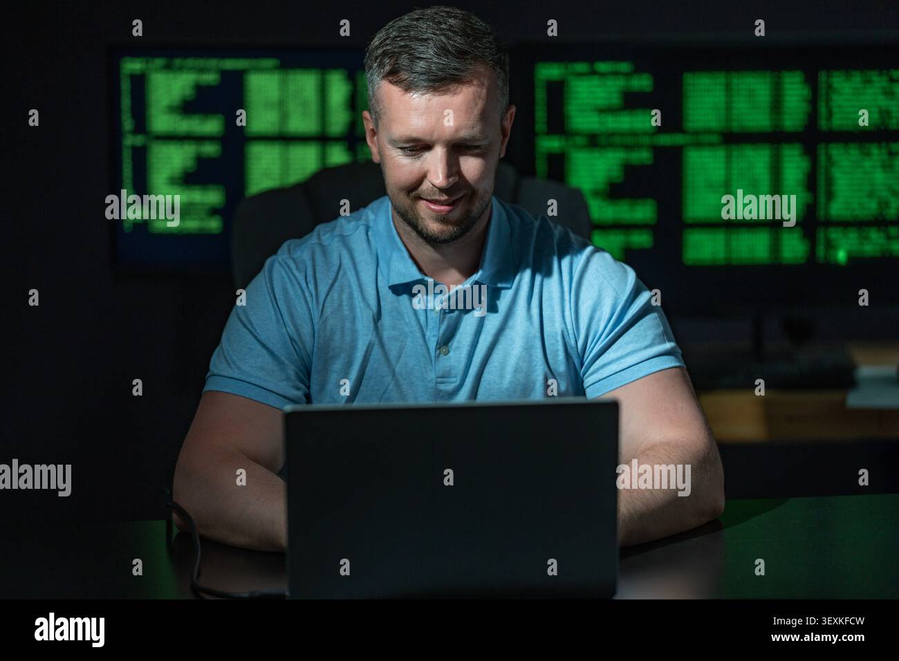 Hacking programmer uses laptop computer. Hacking programmer writes code at night. Hacking programmer monitors server system. Hacking programmer Stock Photo