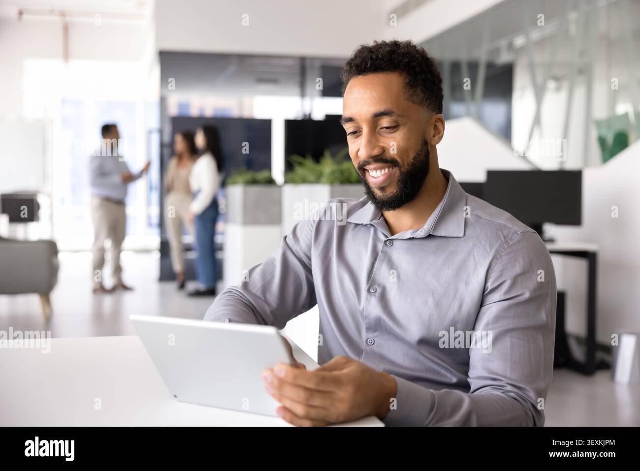 Smiling man using digital tablet in office Stock Photo