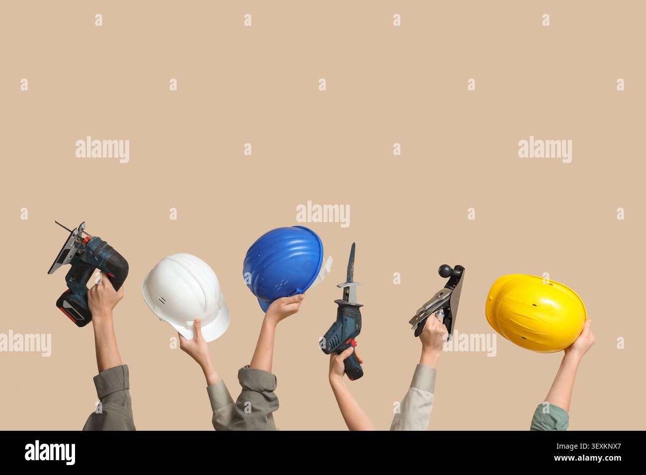 Hands with hardhats and construction tools on beige background Stock Photo