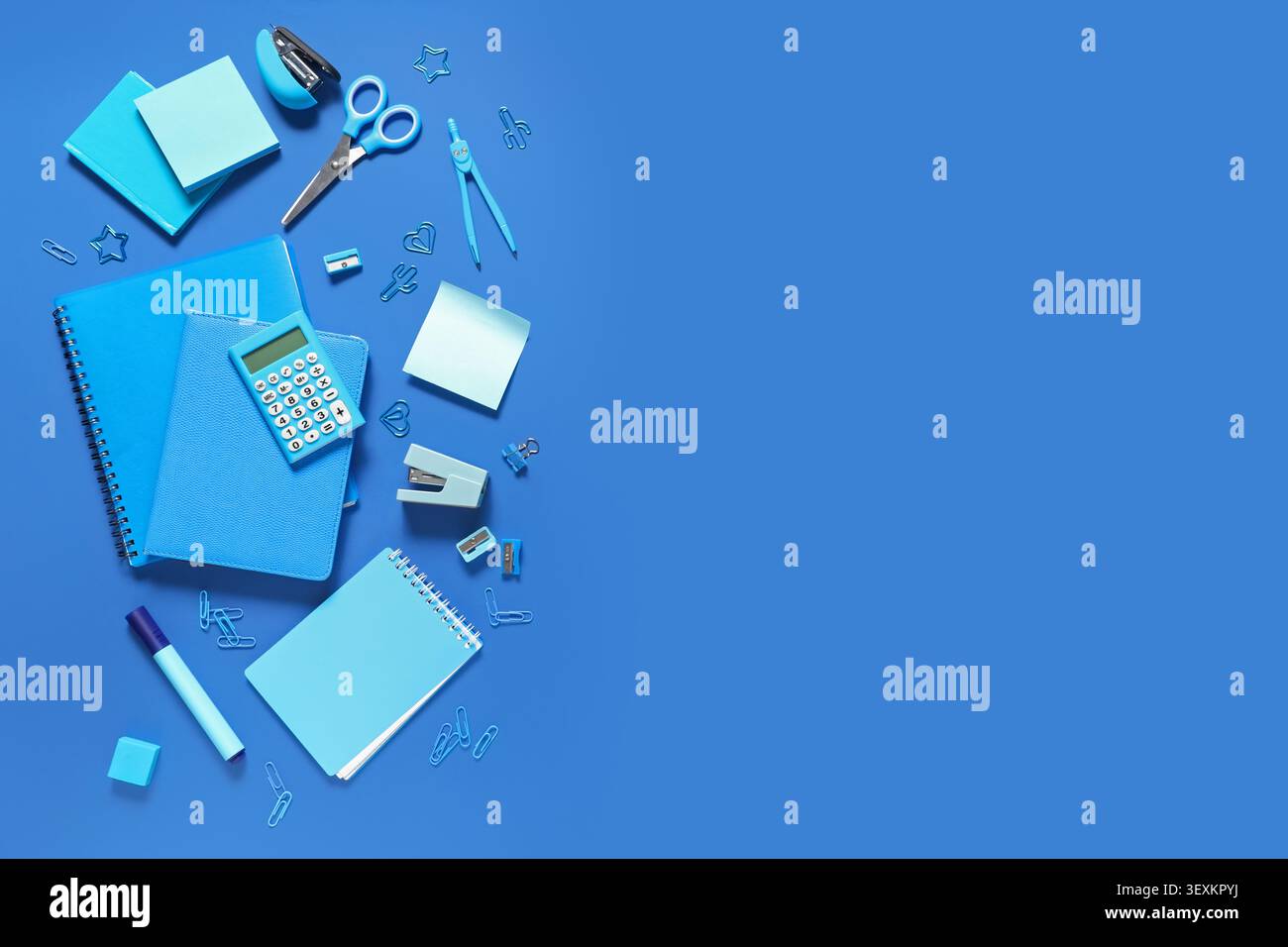 Notebooks and different stationery on blue background Stock Photo