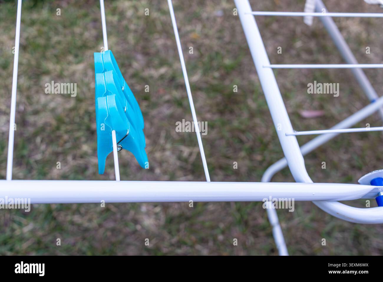 Blue Clothespin on White Clothes Drying Rack Outdoors Stock Photo