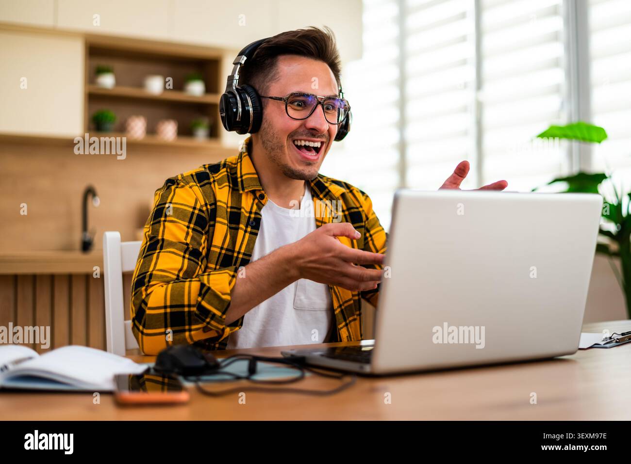 Young man is using laptop for online communication while working at home. Stock Photo