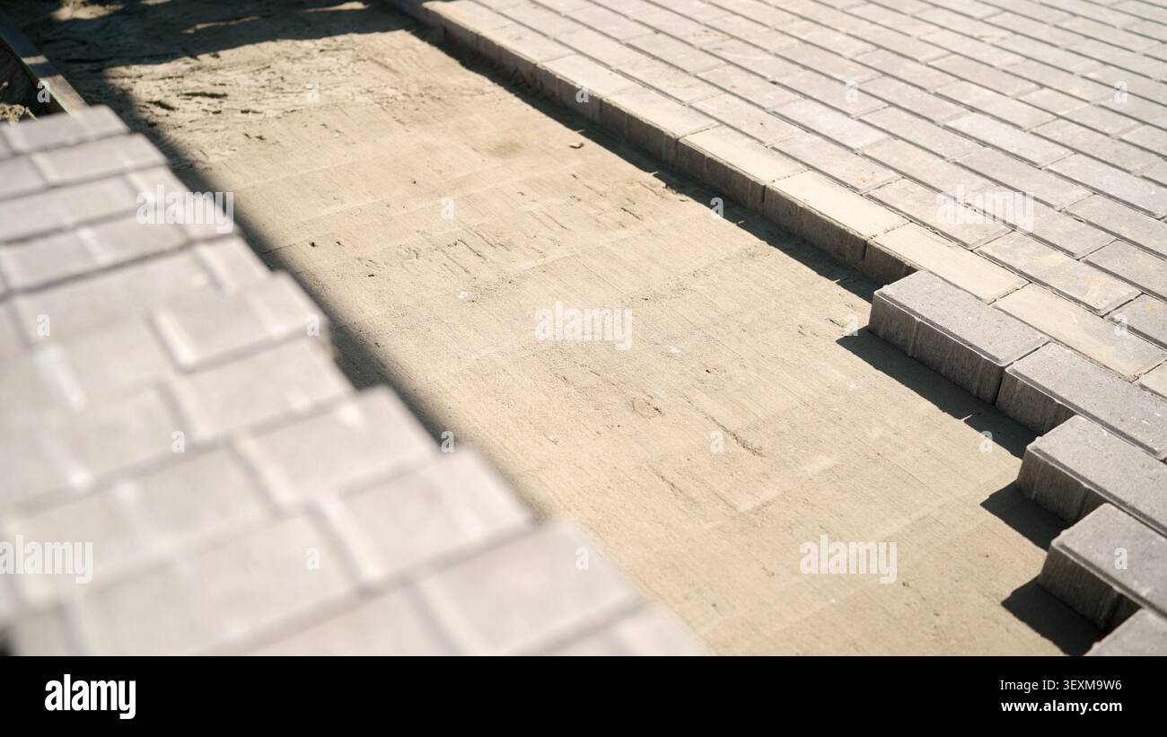 Installing paving stones on sand base constructing patio Stock Photo