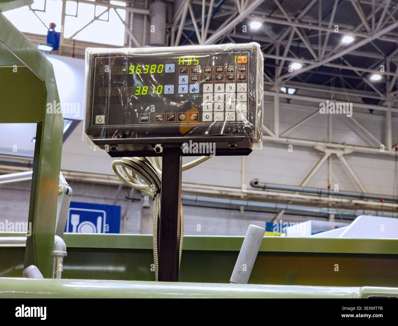 Close-up of a digital readout (DRO) control panel displaying coordinate measurements on an industrial metalworking machine in a factory workshop. Stock Photo