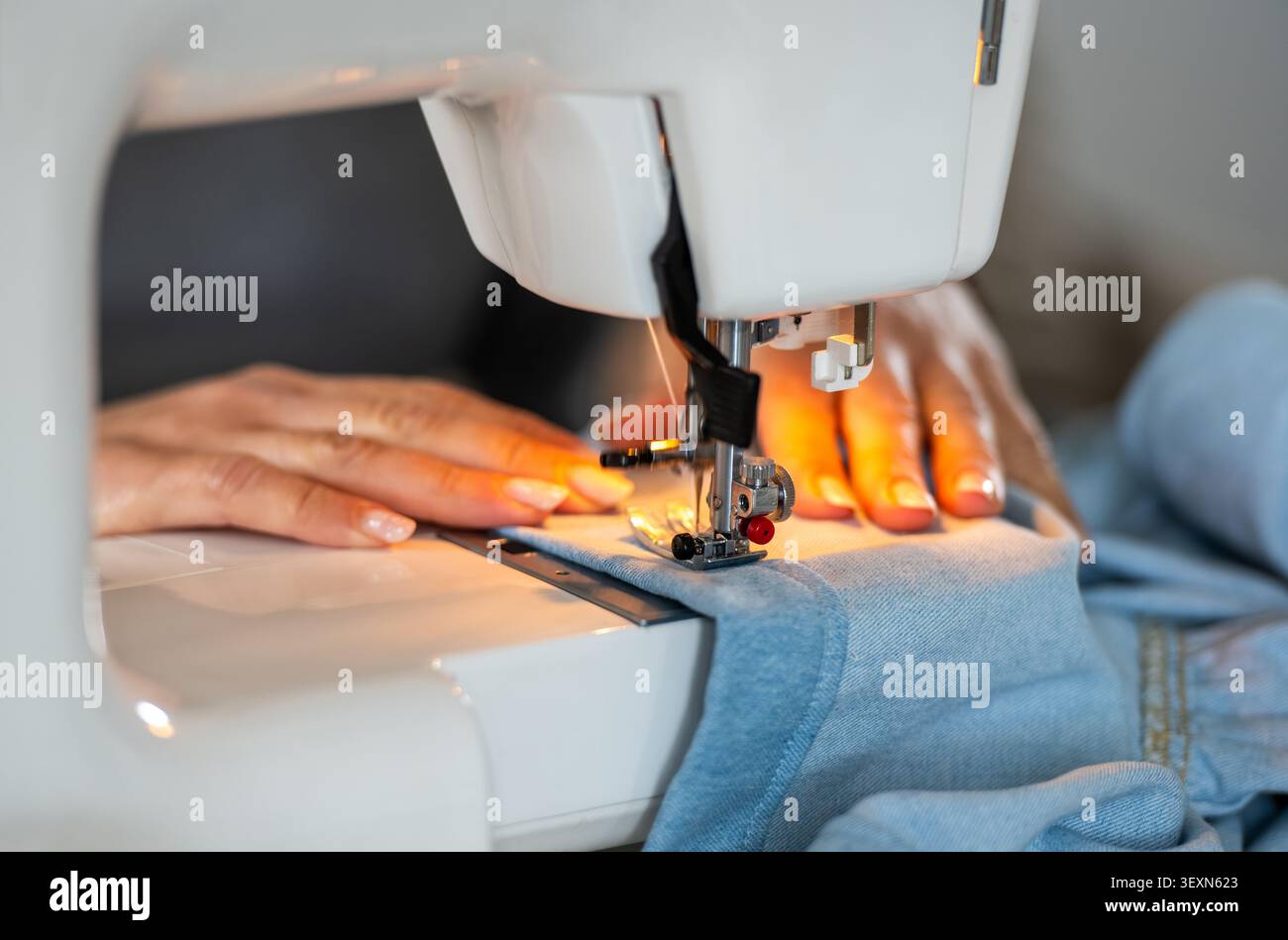 Woman's Hands Sewing On A Machine In Close-Up Stock Photo