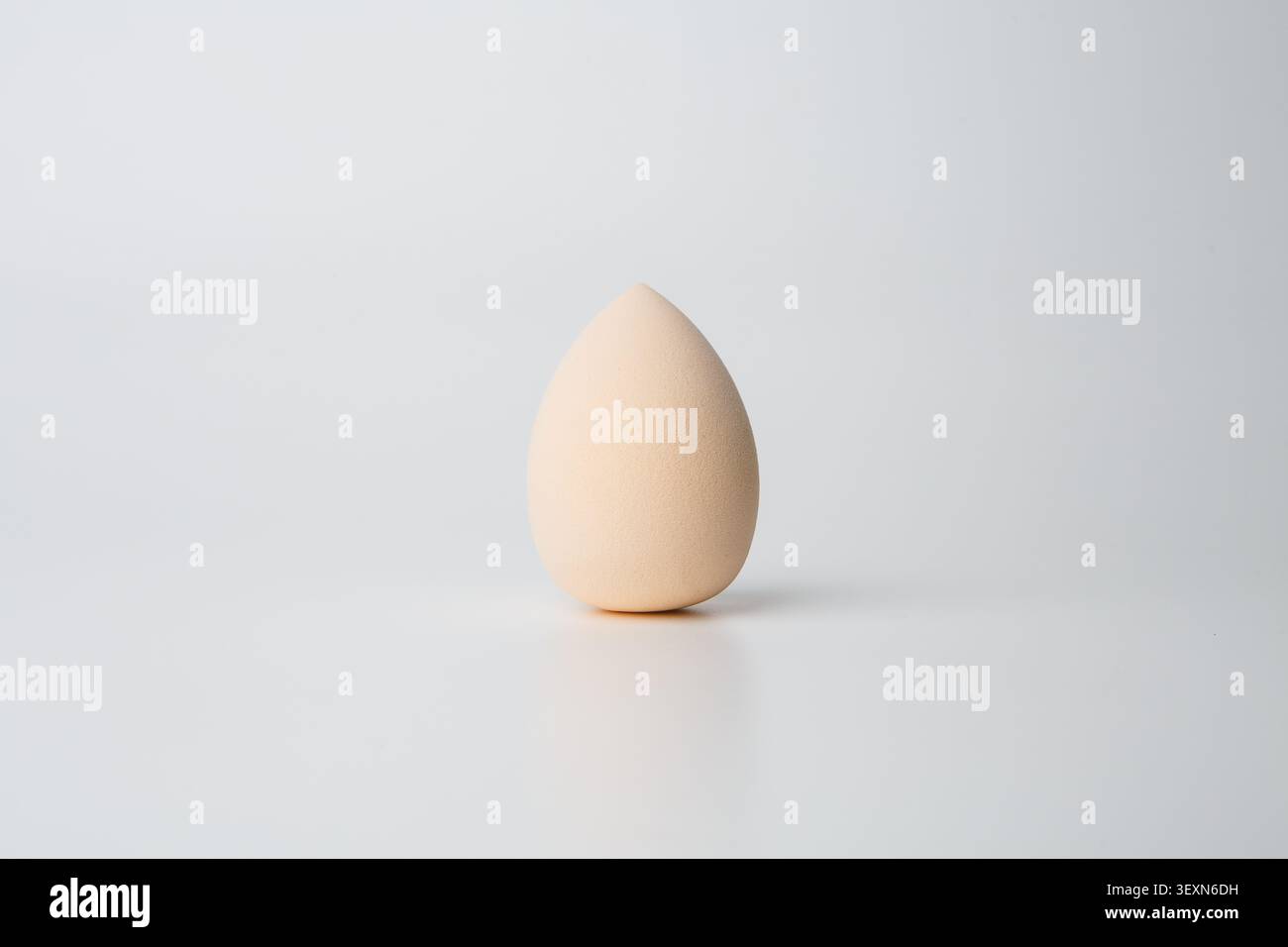Minimal beige makeup sponge on gray background Stock Photo