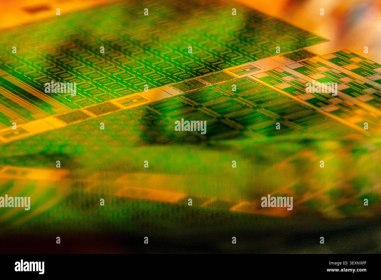 Wafer showing microelectronic circuit patterns creating an abstract, futuristic background Stock Photo