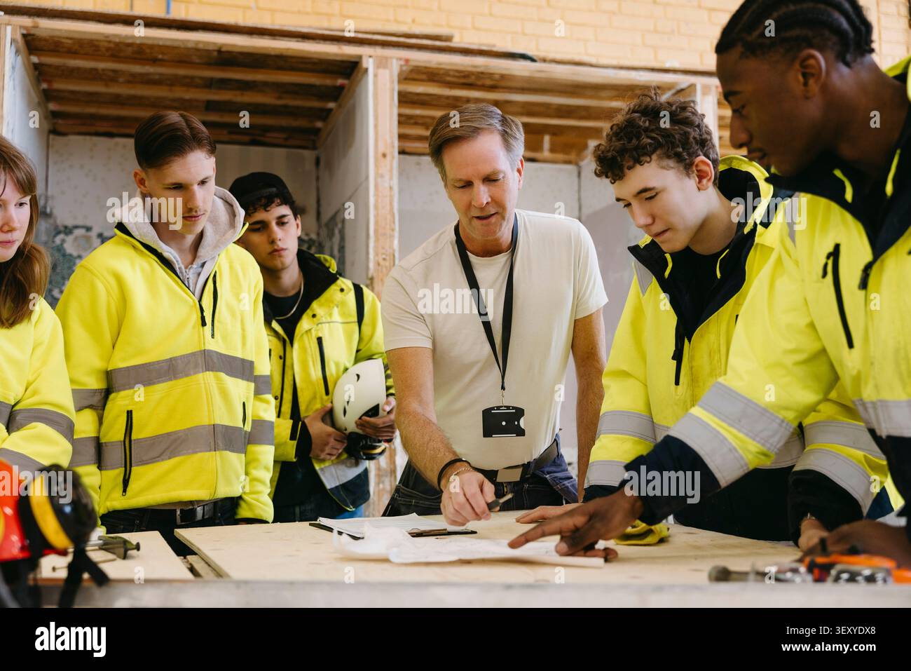 Male vocational instructor teaching students at training session in workshop Stock Photo
