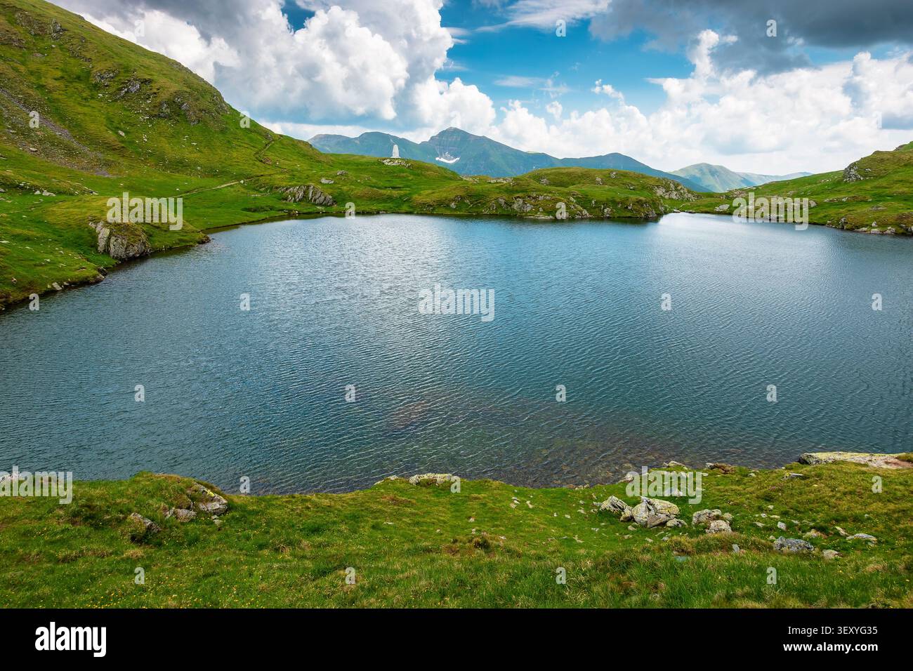 lake in romania mountain landscape. clear source of water. outdoor adventures in summer. cloudy sky over the fagaras ridge Stock Photo