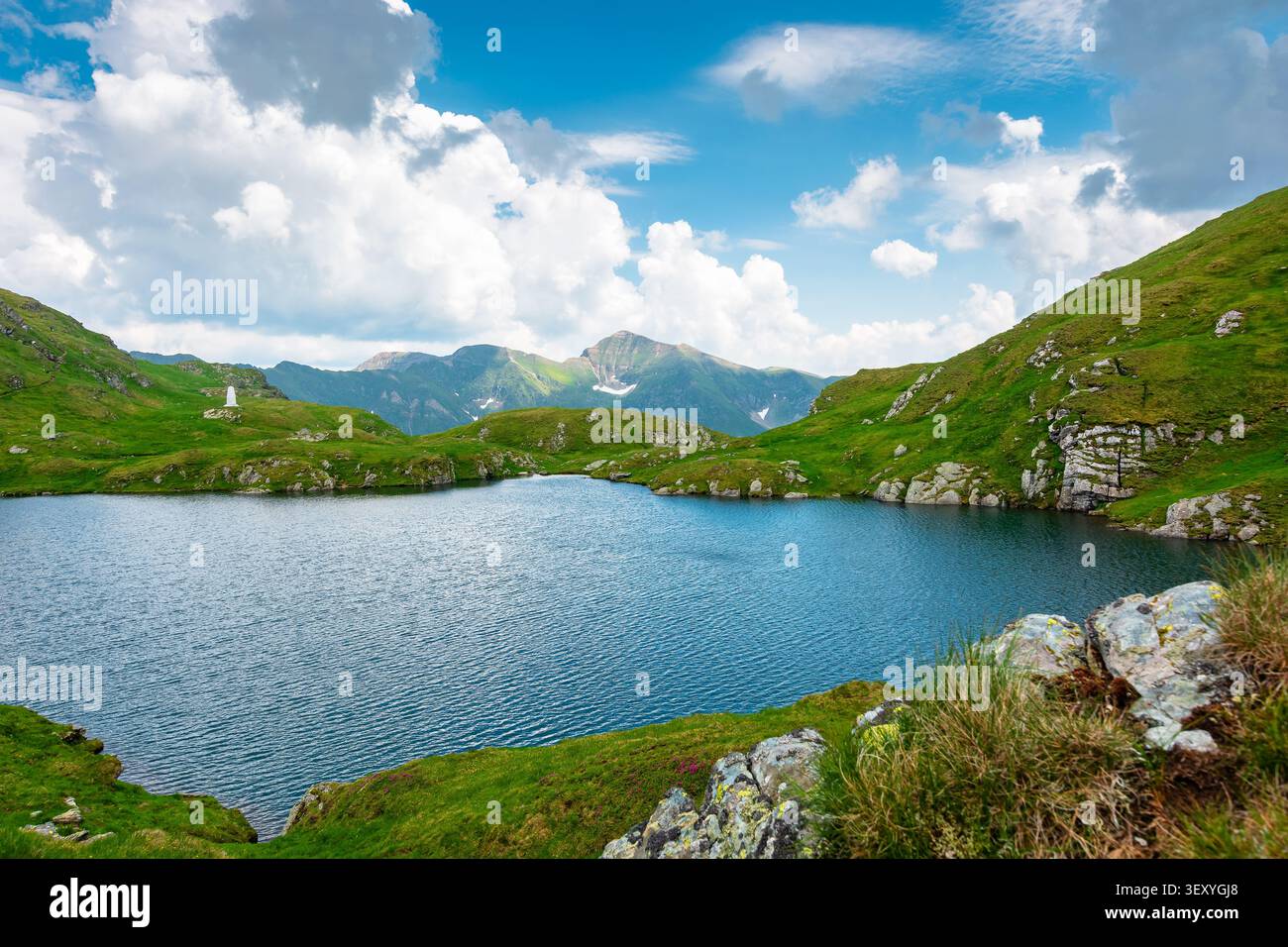 lake in romania mountain landscape. clear source of water. outdoor adventures in summer. cloudy sky over the fagaras ridge Stock Photo