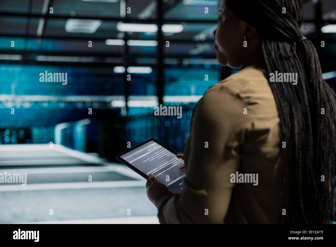System operator uses a digital tablet in a data center to support failure detection and reliable server workflows. Stock Photo