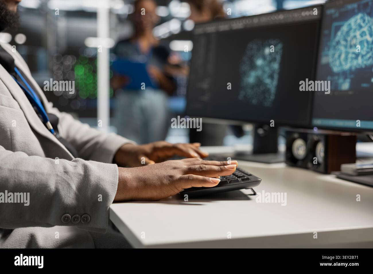 System operator uses a desktop computer in a data center to manage AI systems and optimize server infrastructure. Stock Photo