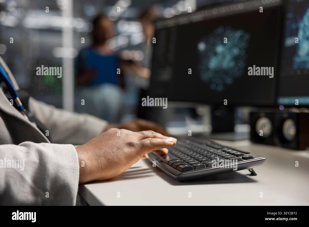 Data center engineer uses a desktop computer in a data center to support failure detection and reliable server workflows. Stock Photo