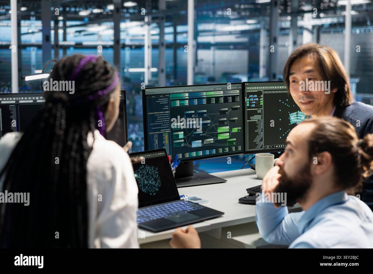 Engineering team works with computer in a data center to support data processing, analytics, and storage infrastructure. Stock Photo