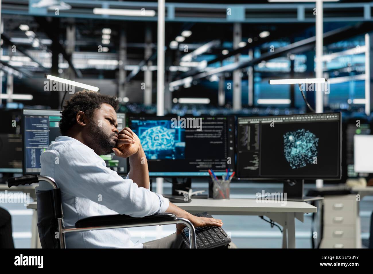 Worker with disability in a wheelchair uses deep learning algorithms in an inclusive server hub to analyze datasets and recognize patterns. Stock Photo