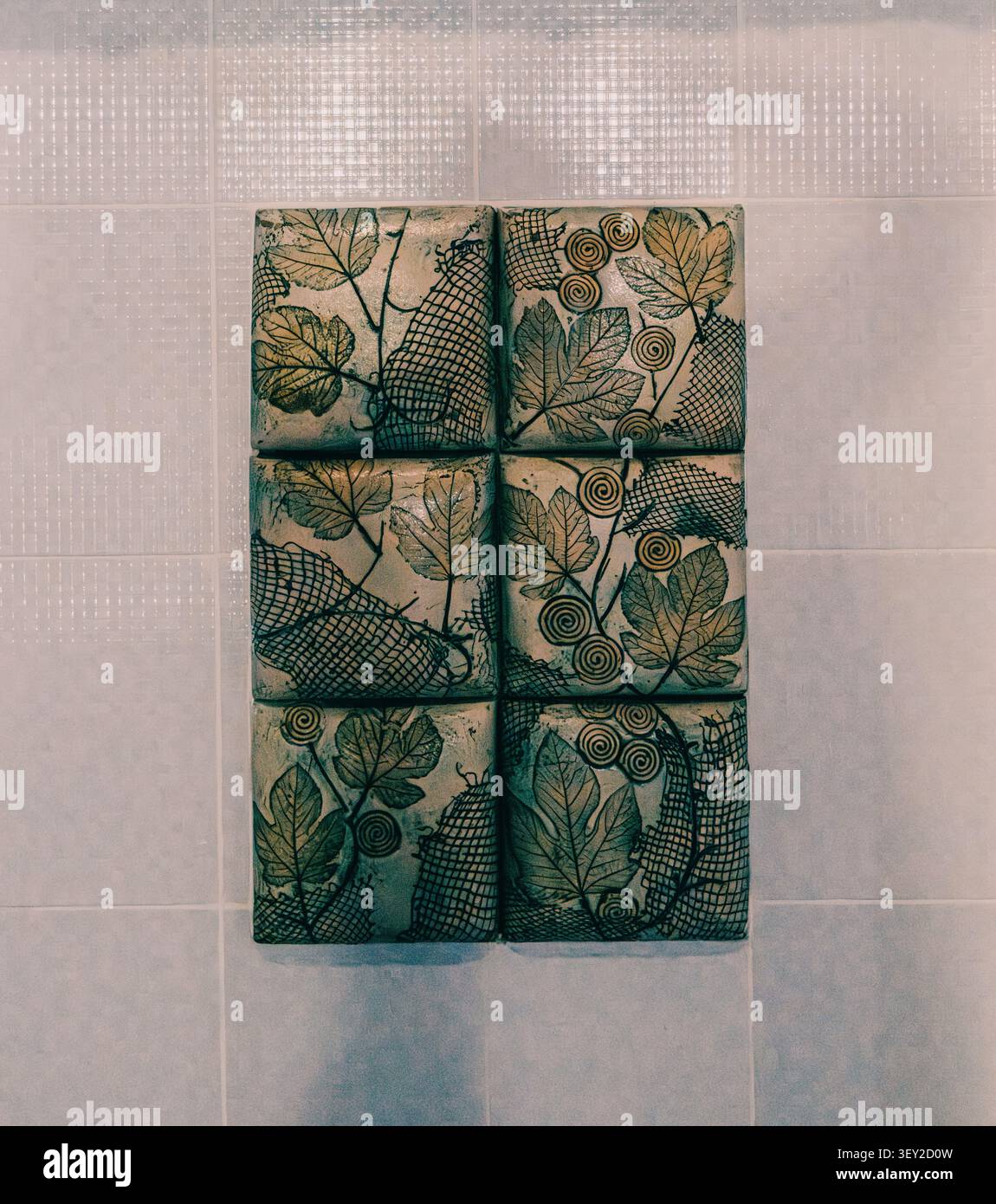 Decorative ceramic tile artwork with botanical leaf patterns. Stock Photo