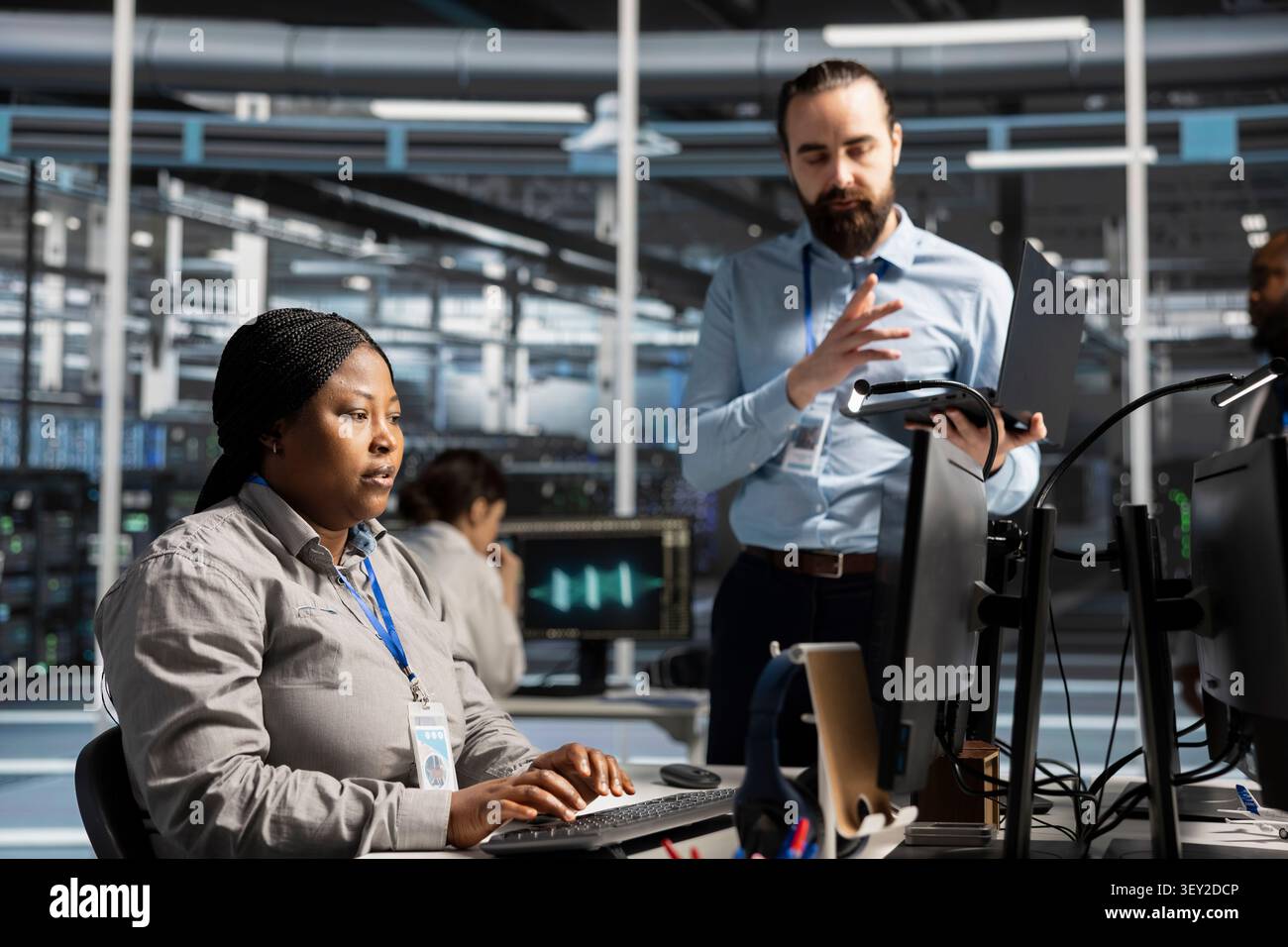 Data center colleagues collaborate on coding and AI automation scripts while reviewing server infrastructure together. Stock Photo