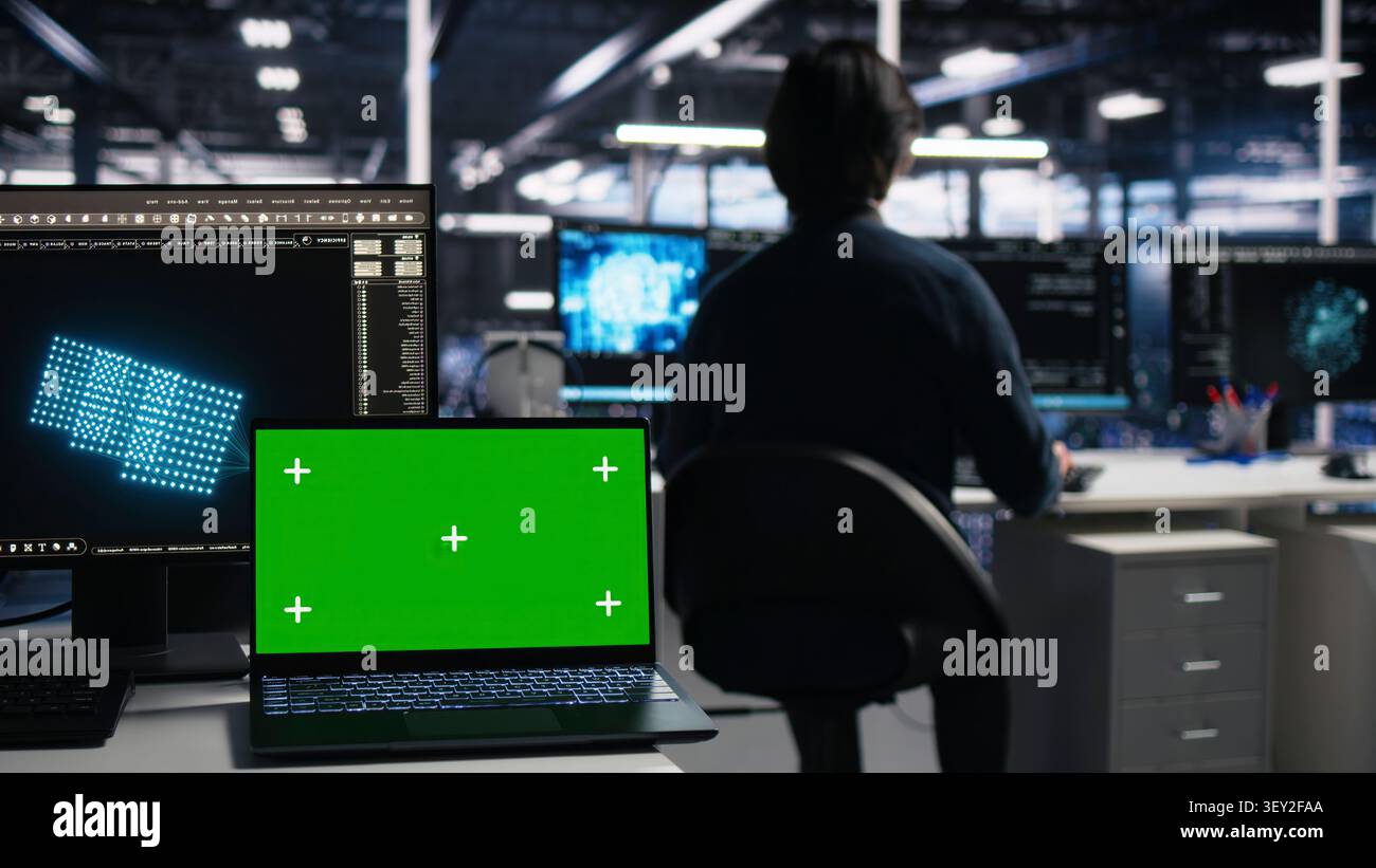 Computer scientist programs on a green screen computer in a data center with generative AI assistance. Stock Photo