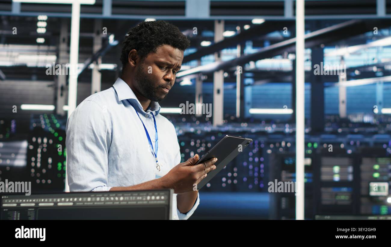 Technician uses a computer workstation in a server farm to categorize unstructured data with node tree systems. Stock Photo