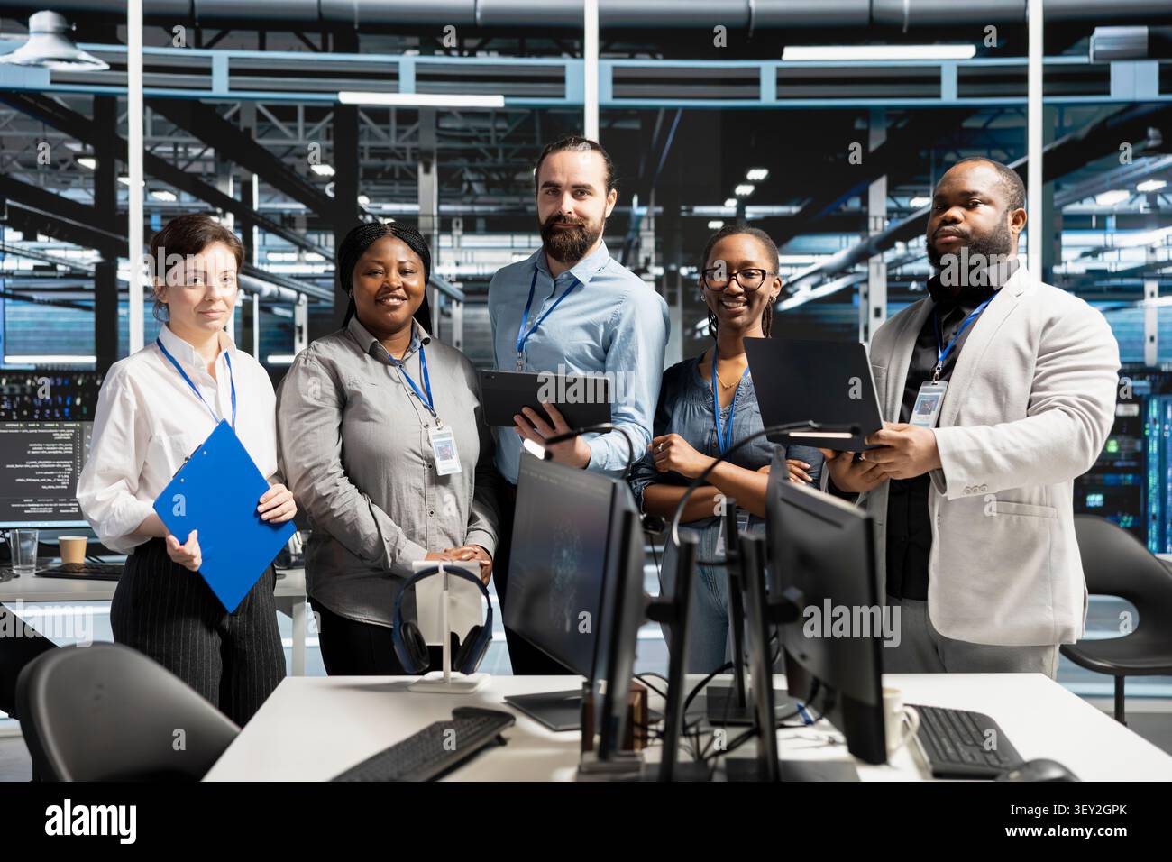 Friendly computing facility IT technician inspecting equipment, doing maintenance tasks. Stock Photo