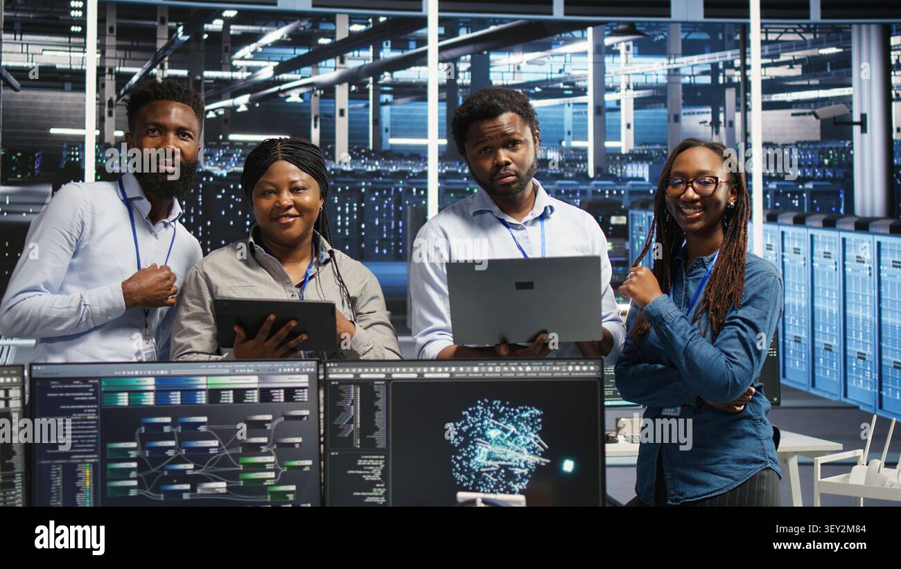 Friendly data infrastructure center specialists collaborating in data infrastructure center. Stock Photo