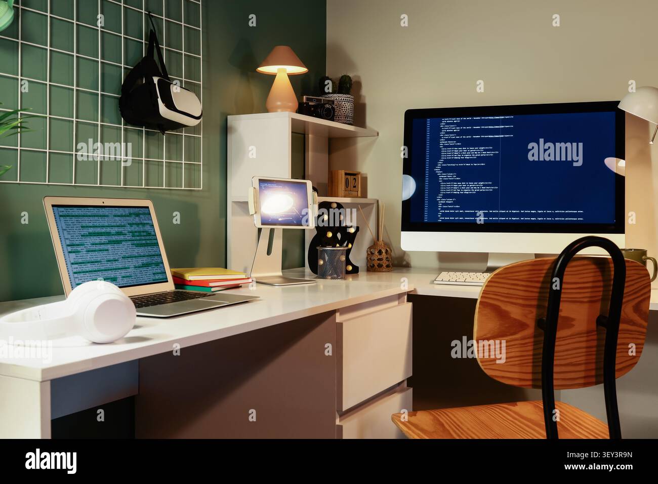 Modern home office workspace with multiple screens and coding Stock Photo