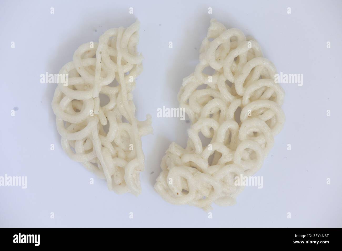 Broken Round Indonesian Cracker Split into Two Pieces on White Background Stock Photo