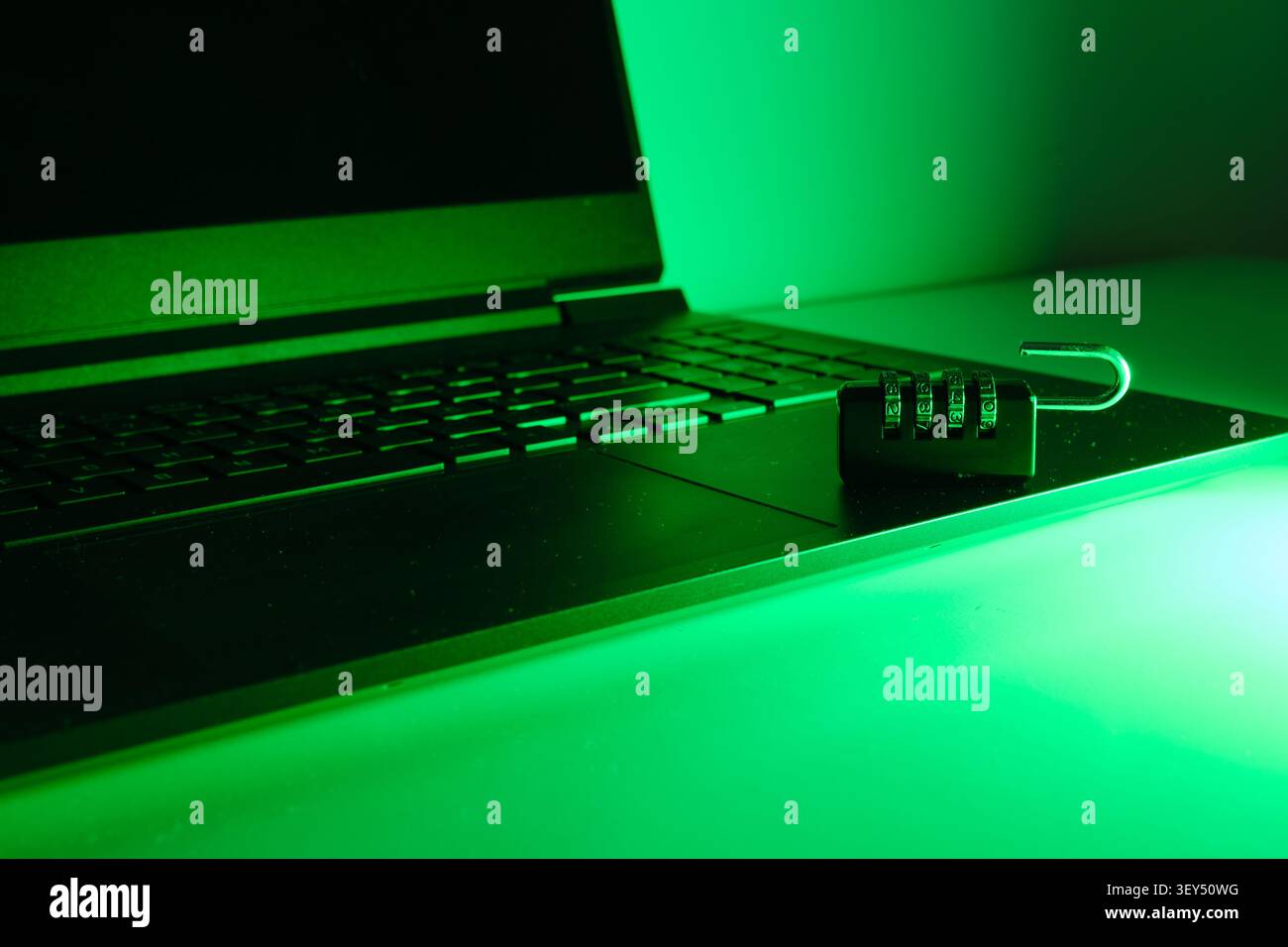 Open padlock resting on a laptop keyboard reflecting data access and security vulnerability Stock Photo
